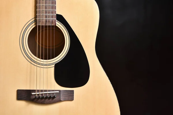 Akustik gitar ve yuvarlak delik yuvası karanlık bir arkaplana karşı kapanıyor ve boşluğu kopyalıyor — Stok fotoğraf