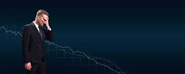 Business person, manager failed and covered his face with his hand on the background of a graph of falling profits and growth on a blue background