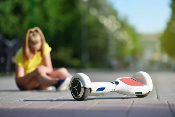 Κορίτσι παιδί έπεσε από ένα hoverboard και τραυματίστηκε γόνατο της, ενώ ιππασία σε ένα πάρκο — Φωτογραφία Αρχείου