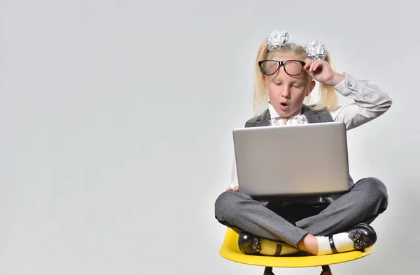 Menina criança com surpresa lê uma mensagem sobre descontos em um laptop — Fotografia de Stock