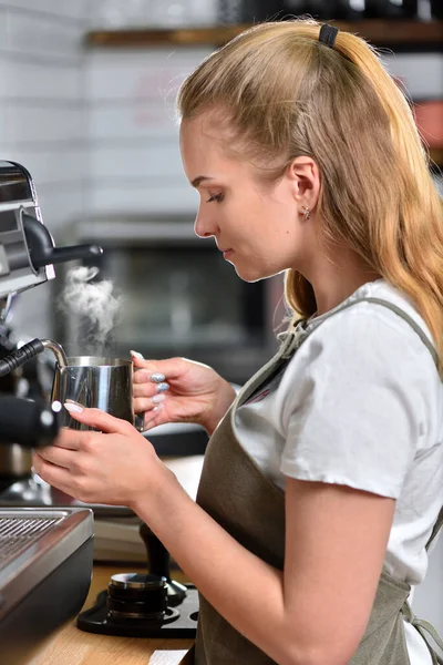 Egy fiatal barista lány kávét főz egy nagy, profi kávéfőzőn. Kisvállalkozás és diákmunka fogalma — Stock Fotó