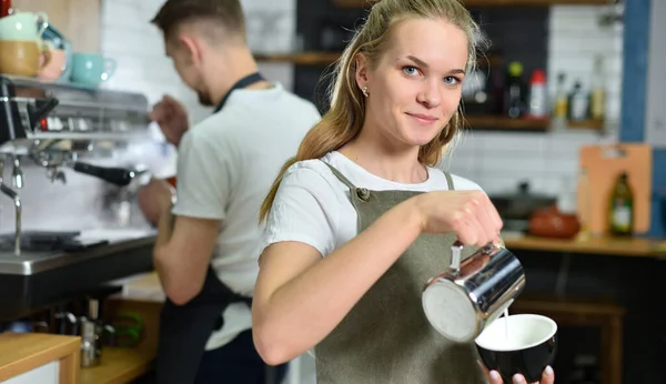 Egy fiatal srác és egy barista lány egy kávézóban dolgoznak és kávét főznek. Koncepciós személyzet és csapatmunka — Stock Fotó