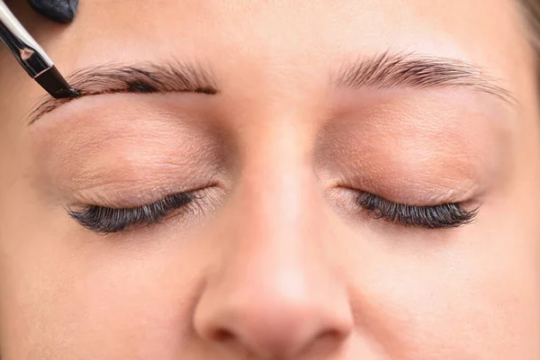 Junge Frau bemalt Augenbrauen mit Henna, Augen in Großaufnahme — Stockfoto