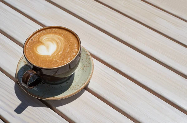 Caneca apetitosa com café em uma mesa de madeira em um restaurante de verão — Fotografia de Stock