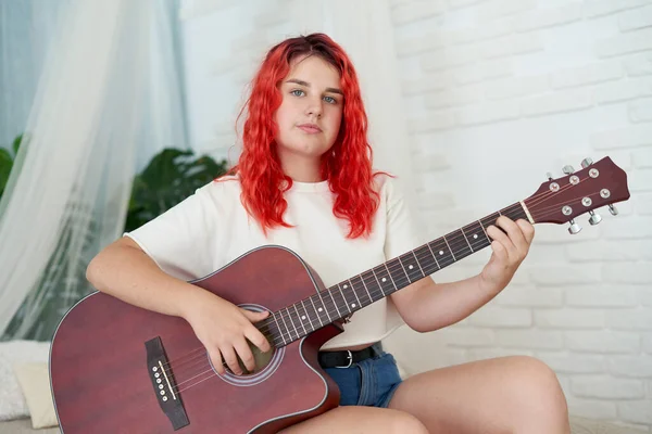 Adolescente 12 anos segurando uma guitarra acústica vermelha — Fotografia de Stock