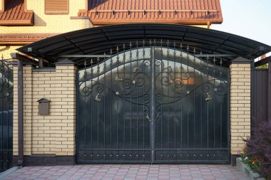 Dekoratif elementlerle dövülmüş siyah metal kapılar