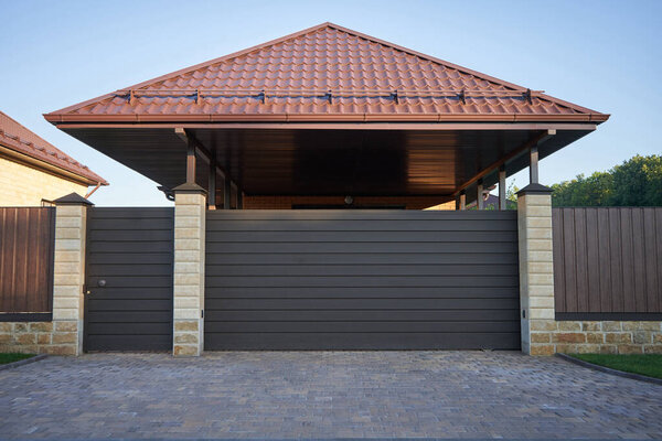 Automatic sliding gates in brown for entrance under a canopy