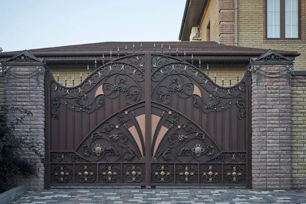 Luxurious metal forged gates and brick fence in a private house — Stock Photo, Image