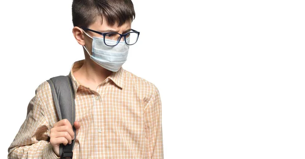 Portrait of a schoolboy in glasses and a protective mask with a strained look on a white isolated background — Stock Photo, Image