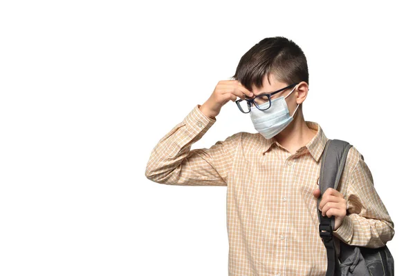 Colegial blanco caucásico usando una máscara protectora tocando una cabeza enferma sobre un fondo blanco aislado —  Fotos de Stock