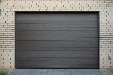 Tuğla duvar ve modern otomatik garaj kapısı.