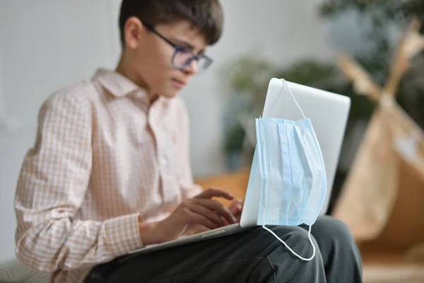 Máscara protetora no monitor de laptop e adolescente estressante no ensino à distância — Fotografia de Stock