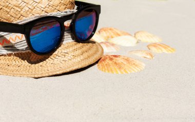 Eski yaz hasır hasır hasır hasır plaj şapkası ve güneş gözlükleri deniz kenarında sahilde