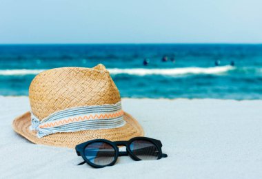 Eski yaz hasır hasır hasır hasır plaj şapkası ve güneş gözlükleri deniz kenarında sahilde