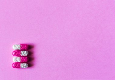 Pembe arka planda yığınla hap, tablet, kapsül. Fotokopi alanı arka planında tedavi için ilaç reçetesi