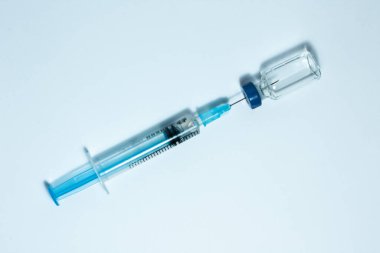 Aşı için mavi alüminyum kapaklı ve şırıngalı cam ilaç şişesi. Kanser, ağrı ve diyabet tedavisi, ilaç konsepti 