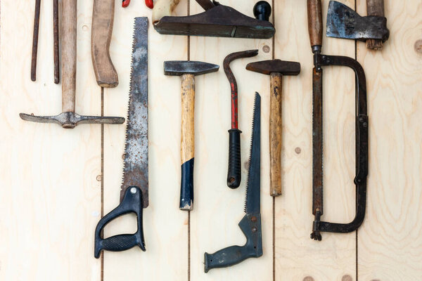 Set of vintage well used hand construction tools for handyman, hammers, on a wooden background 