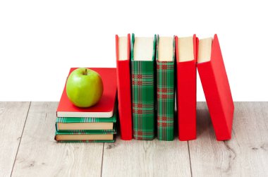 Okula geri döndüm, renkli örtüler içinde bir yığın kitap ve beyaz arka planlı ahşap masada yeşil elma. Uzaktan eğitim. Karantina konsepti: