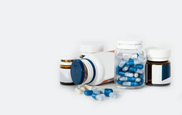 Синие Таблетки Стеклянных Пластиковых Бутылках Белом Фоне Концепция Здравоохранения — стоковое фото