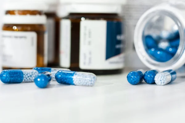 白い背景にガラスとプラスチックボトルの青い丸薬 健康管理の概念 — ストック写真