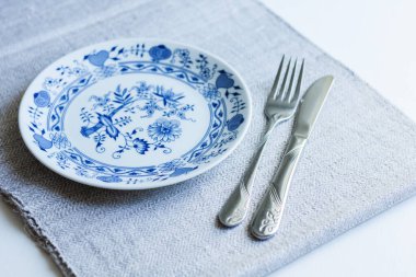 Akşam yemeği için masa seti: bir tabak, bir çatal, örülmüş kumaş peçeteye işlenmiş bir bıçak, Ukrayna 'da geleneksel el yapımı.