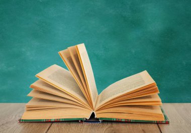 Tahta kapaklı ahşap masanın ders kitabını aç. Uzaktan eğitim. Okula dönmek, karantina konsepti evde kalmak.