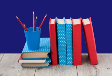 Kitaplar mavi arka planda renkli kapaklar halinde. Okul mesafesindeki ev eğitimine geri dönüyoruz. Evde kalma karantina kavramı.