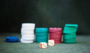 Kumarhane poker çipleri yeşil keçeli keçe grubuna zar yığıyor