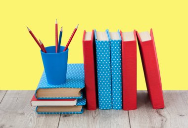 Kitaplar sarı arka planda renkli kapaklar halinde. Okul mesafesindeki ev eğitimine geri dönüyoruz. Evde kalma karantina kavramı.