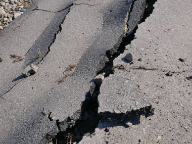 Denize giden yol. Çatlak asfalt dokusu.