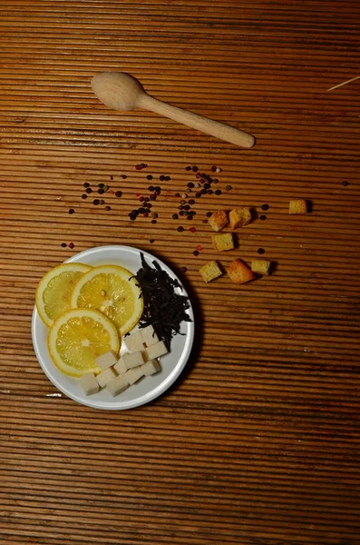 çilek ve bir tahta kaşık bir ışık babukovy arka plan kopya alanı üzerinde bir plaka üzerinde çay şeker limon parçaları dağılmış