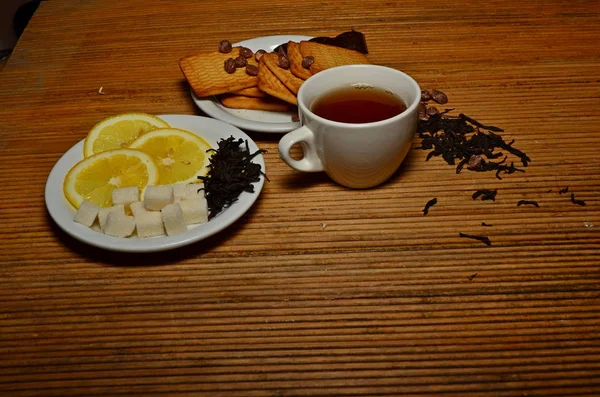 A cup of tea candy lemon cookies on a plate near the tea dumped white black green copy space — Stock Photo, Image
