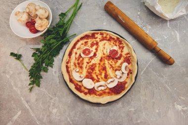 üstten görünüm ile kısmen pişmiş pizza üzerinde bir gülümseme şeklinde, çok sayıda mantar ve mutfak Aksesuar Ürünlerinde sundu