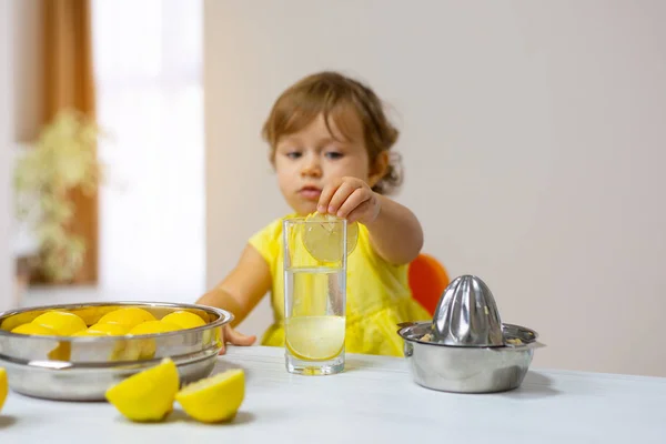 Маленькая Девочка Жёлтом Платье Подаёт Стакан Лимонада Ломтиком Лимона — стоковое фото