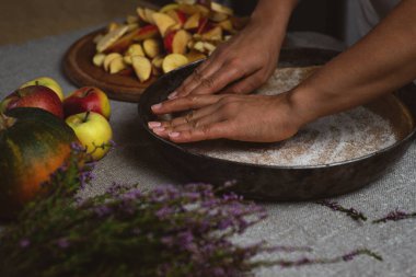 Hazırlık, Şükran Günü kutlaması. Yan görüş. Bir aşçı, elmalı turta için şeker tanelerini hamurun yüzeyine eşit olarak yayar..