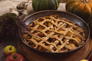 Hazırlık, Şükran Günü kutlaması. Fırında elmalı turta. Yakın plan. Arka planda balkabakları var. Geleneksel elmalı turta yapıyorum..