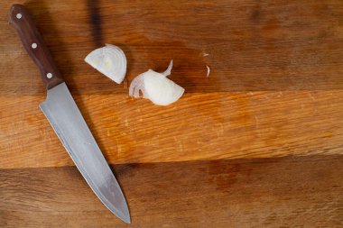 Bıçak ve soğanlı ahşap bir tahtanın üst görüntüsü. Yarım halkalar..