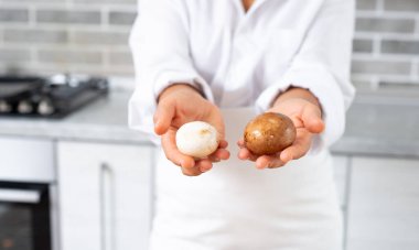 Şefin elleri farklı tonlardaki mantarları gösteriyor..