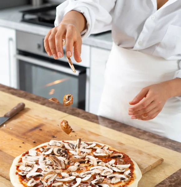 Vista Las Manos Del Chef Lanzando Setas Sobre Superficie Pizza —  Fotos de Stock