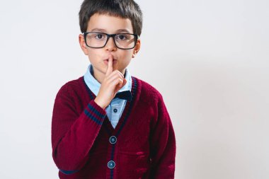 Gözlüklü ve kırmızı kazaklı bir çocuğun portresi parmağını dudaklarına dayayıp sessizlik istedi..