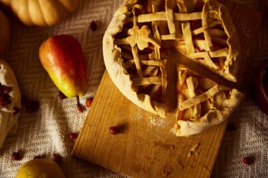 Kırsal bir sonbahar sahnesinde, elmalar ve armutlarla çevrili ahşap bir tahtanın üzerinde kafes kabuklu bir turta yer alır. Sıcak, samimi melodiler Şükran Günü 'nü ve aile toplantılarını hatırlatıyor..