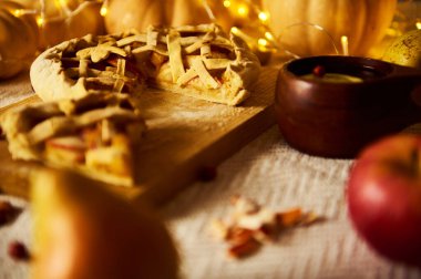 a rustic autumn scene with a lattice-crust apple pie on a wooden board, glowing lights, and a warm, cozy holiday mood - ideal for Thanksgiving, family, home, and harvest themes.