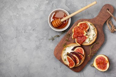 incir, ricotta, bal ve gri bir arka plan üzerine kekik ile sandviçler. yukarıdan görüntülemek