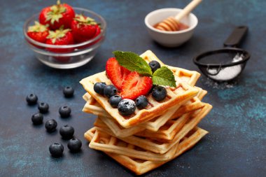 yığın böğürtlen ve çilek ile Belçika Waffle mavi bir arka plan üzerinde tatlım