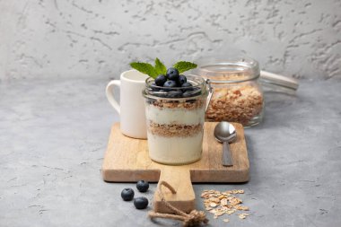 sağlıklı diyet kahvaltı. granola, yoğurt, yaban mersini gri beton zemin üzerine bir kavanoza. kopya alanı