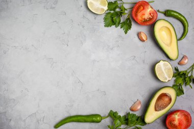 Guacamole için malzemeler: avokado, limon, domates, soğan ve baharat gri bir arka plan üzerinde. yukarıdan görüntüleyin. kopya alanı