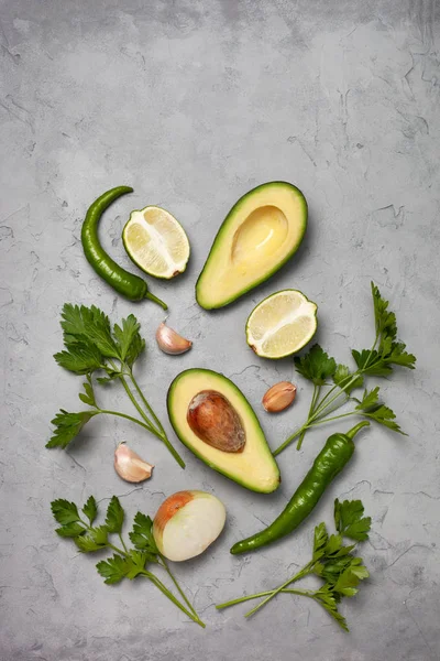 Guacamole için malzemeler: avokado, kireç, soğan ve siyah bir zemin üzerine baharat. yukarıdan görüntüleyin. kopya alanı