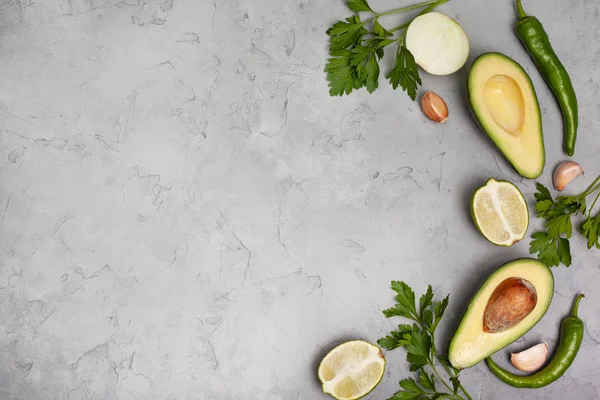 Guacamole için malzemeler: avokado, kireç, soğan ve siyah bir zemin üzerine baharat. yukarıdan görüntüleyin. kopya alanı