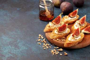 ricotta, incir ve mavi bir arka plan üzerinde ballı sandviç