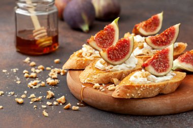 ricotta, incir ve kahverengi bir arka plan üzerinde ballı sandviç